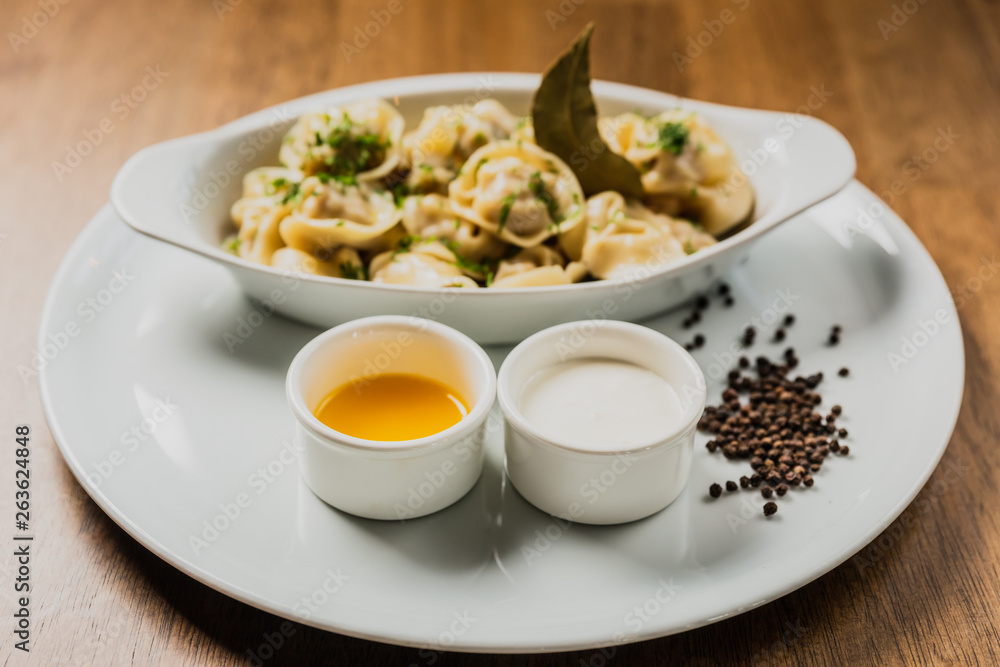 Meat dumplings or pelmeni served with sour cream and dill Meat dumplings or pelmeni served with sour cream and dill