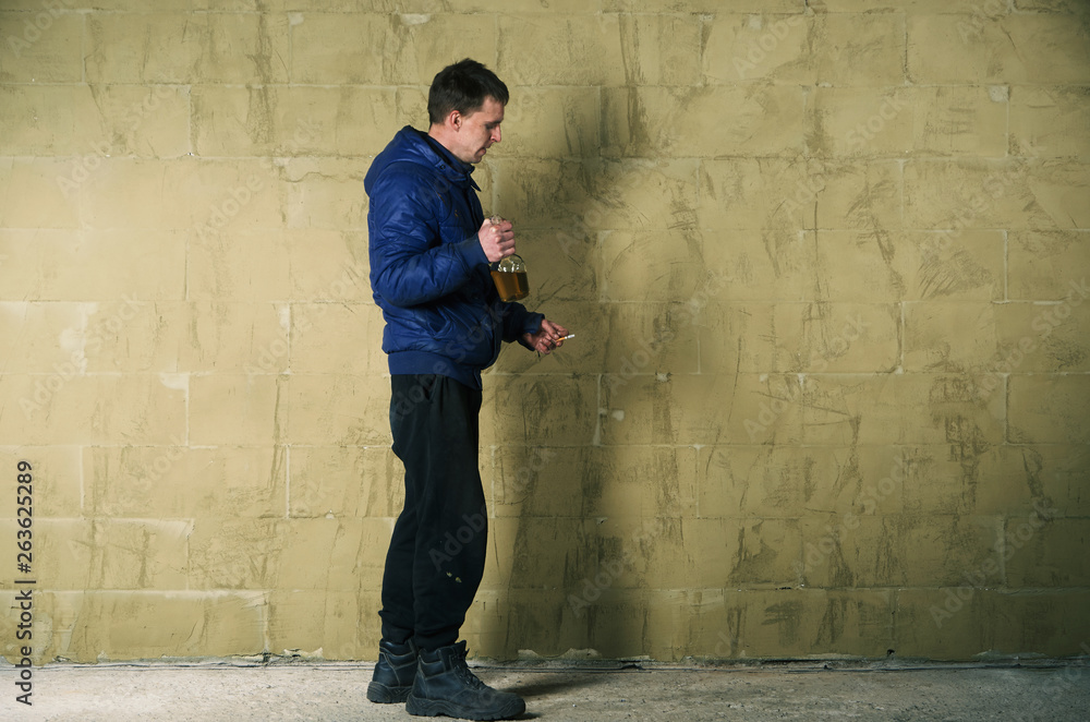 A disheveled man with alcohol in his hand. A disheveled man with alcohol in his hand.