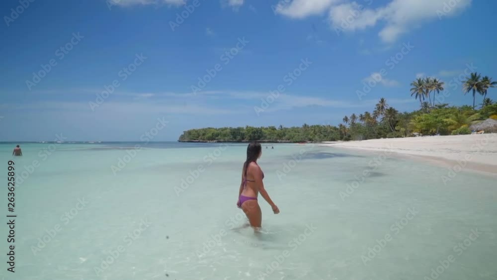 Slow Motion: Beautiful Young Woman in Bikini Standing in Clear Tropical Ocean in El Limon, Dominican Republic Slow Motion: Beautiful Young Woman in Bikini Standing in Clear Tropical Ocean in El Limon, Dominican Republic