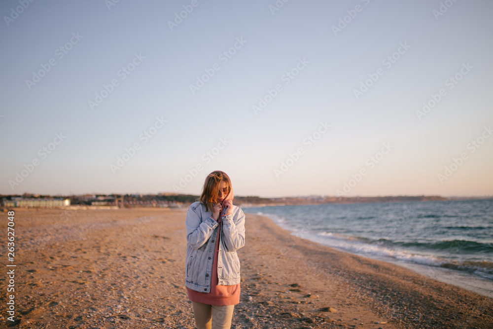 Young beautiful happy woman having good time at the beach on sunset time