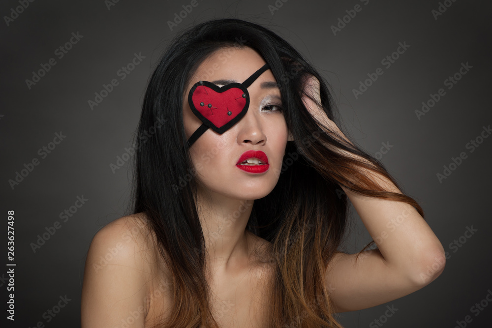 Portrait of beautiful woman with heart shape eye patch Portrait of beautiful woman with heart shape eye patch