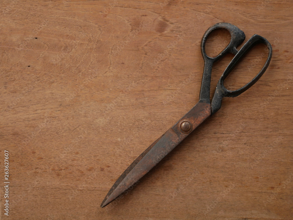 old scissors on wooden background old scissors on wooden background