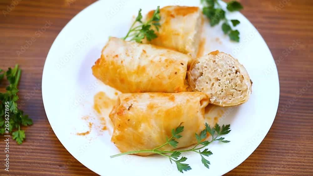 stewed cabbage rolls with meat filling inside in a plateon a wooden table stewed cabbage rolls with meat filling inside in a plateon a wooden table