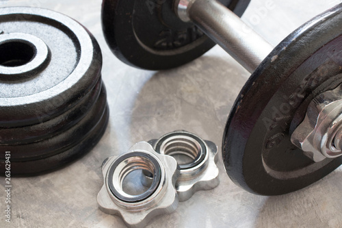 Fitness or bodybuilding concept background. Product photograph of old iron dumbbells on grey, conrete floor in the gym.