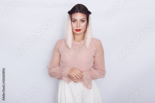 Romantic portrait of blonde woman in light pink blouse