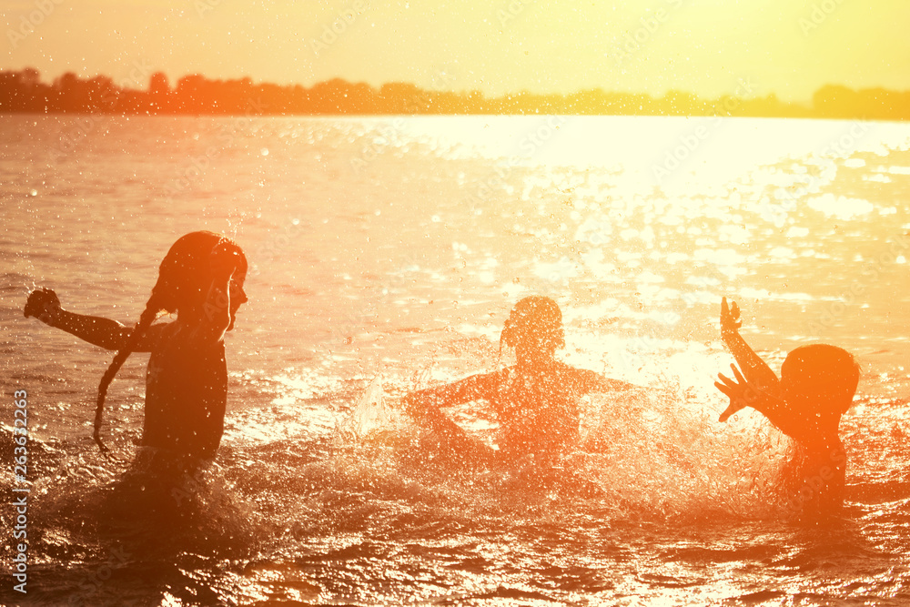 Jumping in the water. Kids have fun and splash in the water. Summer holiday concept