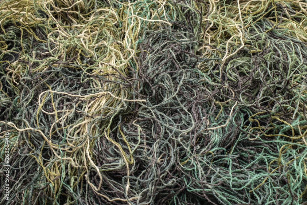 background of colored threads chaotically intertwined. green yellow and brown threads matted in a colorful background