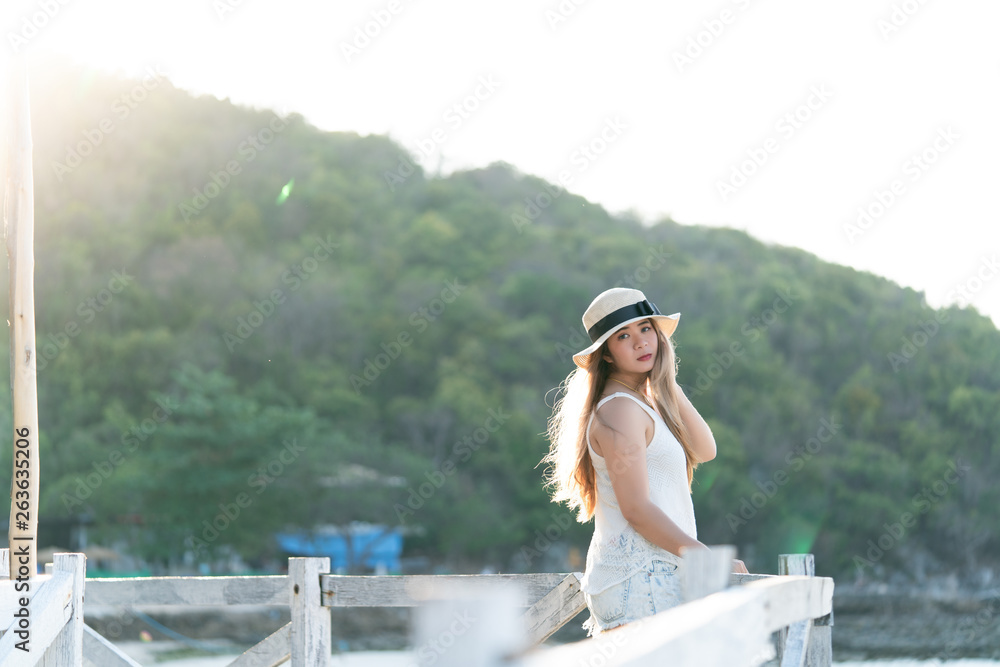 Beach vacation,young woman in sunhat enjoying looking view of beach ocean on hot summer day. 
