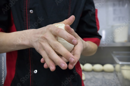 Restaurant kitchen. Chef holding a piece of dough