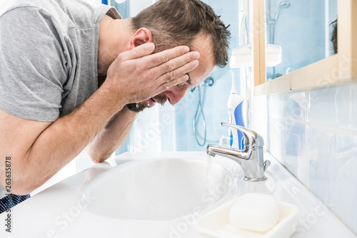 Man washing his face in bathroom © Voyagerix