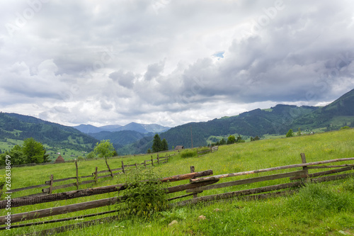 Mountain slope with fenced hayfields on a foreground