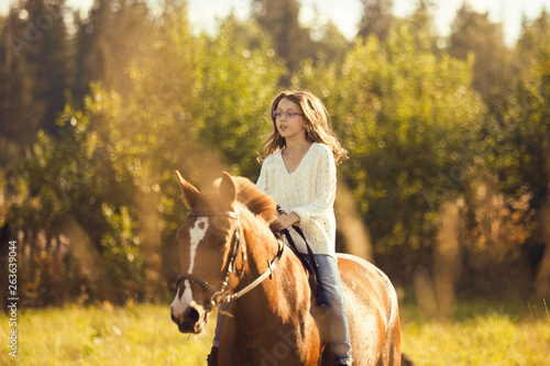Young girl goes sorrel horse riding © Olga