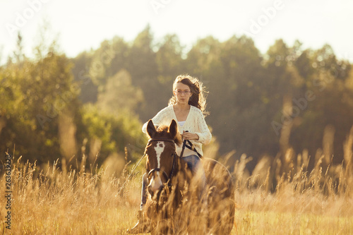 Young girl goes sorrel horse riding