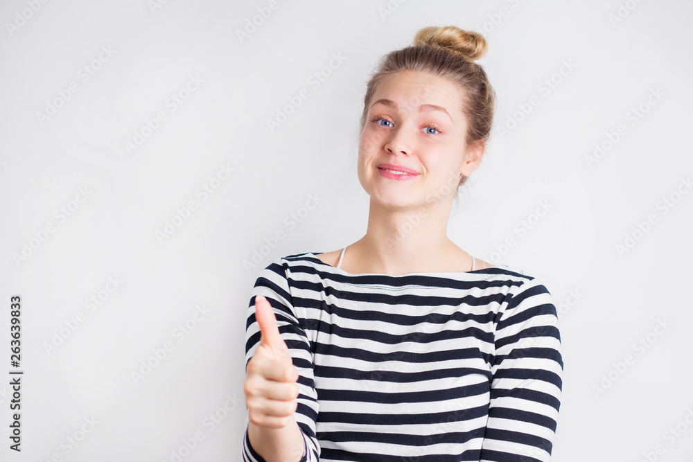 Portrait of young smiling blonde woman showing finger up sign Portrait of young smiling blonde woman showing finger up sign