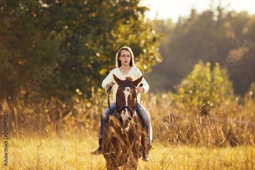 Young girl goes sorrel horse riding