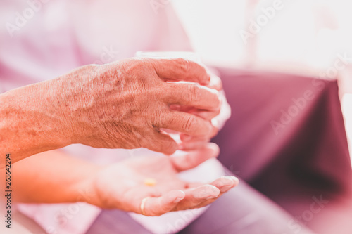 senior asian couples take pill with glass of water, selective focus