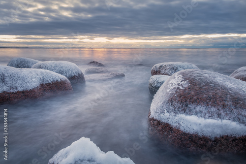 Scenic winter landscape with sea and sunrise at morning. Beautiful light with rocky coast in Finland.