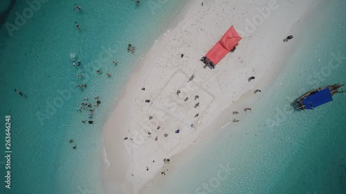 Group of young people plying beachvolley and swimming on a lone bounty island in the Indian ocean photo