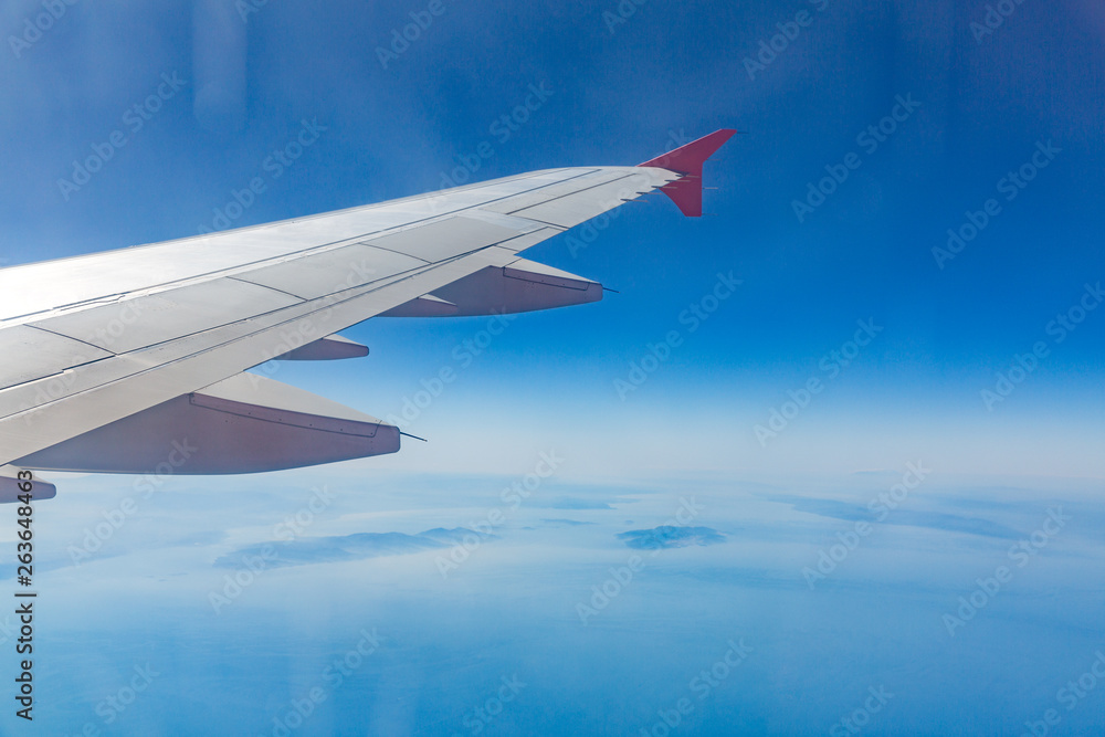 Fototapeta premium Wing of an airplane. Traveling concept. Aircraft wing on the clouds