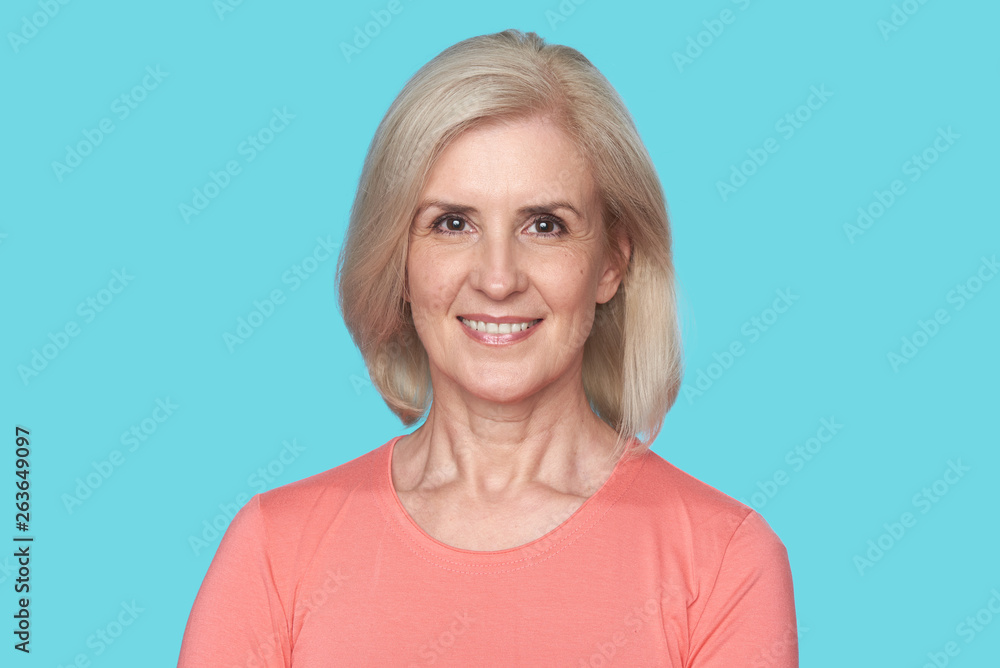Old beautiful woman with toothy smile isolated over blue background Old beautiful woman with toothy smile isolated over blue background
