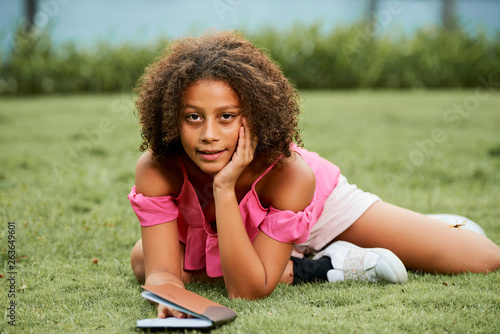 African girl with diary lying on grass