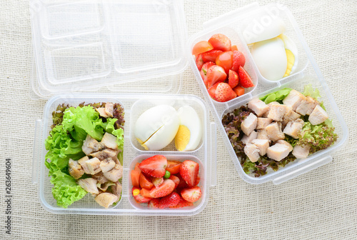 Modern style clean food, boiled egg, grilled chicken and avocado, strawberry, vegetable salad.