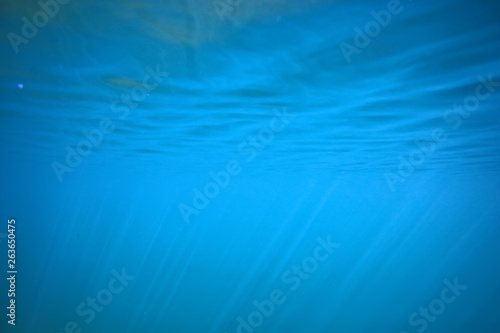 ocean water blue background underwater rays sun / abstract blue background nature water