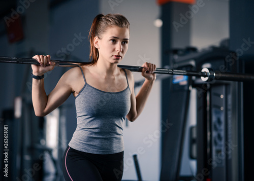 Attractive Young Sports Woman Doing Lunges with Barbell in the Gym. Fitness and Healthy Lifestyle.