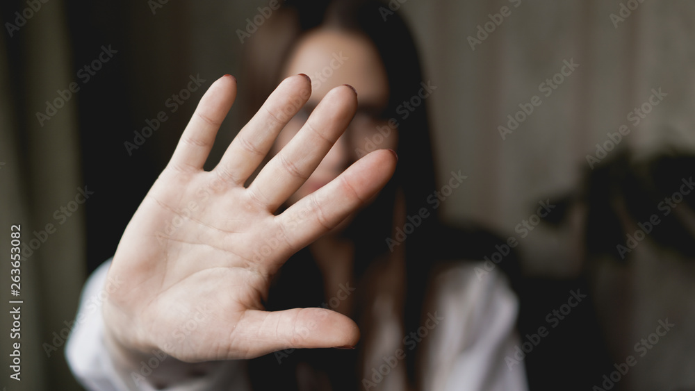 Woman with her hand extended signaling to stop - her hand is in focus - obrazy, fototapety, plakaty 