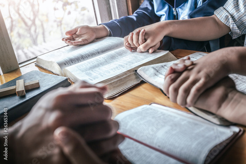 Canvas Print Christian group praying together around table at home, prayer meeting concept