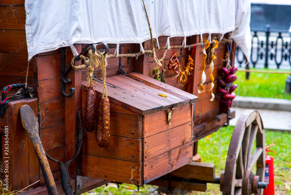 wooden cart with products in front of an old farm