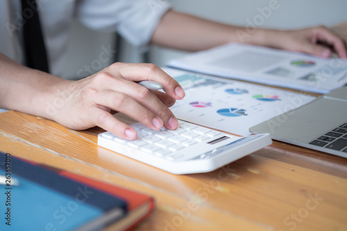 Businessman making calculation with pen in hand, finances concept