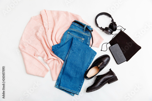 Women's fashion clothing and accessories. Female youth collage on white background top view. A flat lay-out in feminine style looks with a warm sweater, jeans, shoes. Top view. 