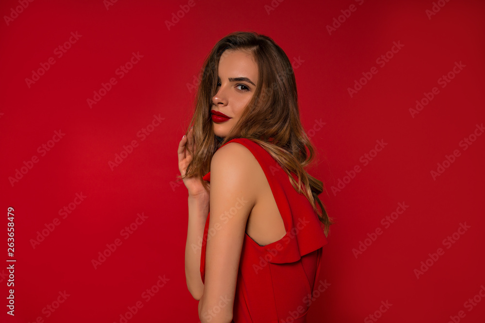 Close up inside studio portrait of adorable stylish woman with red lips and wearing red dress over isolated background Close up inside studio portrait of adorable stylish woman with red lips and wearing red dress over isolated background