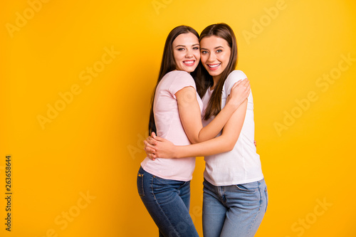 Close up side profile photo two people beautiful she her ladies models full emotions feelings best buddies fellowship hugging stand close wear white pink casual t-shirts isolated yellow background