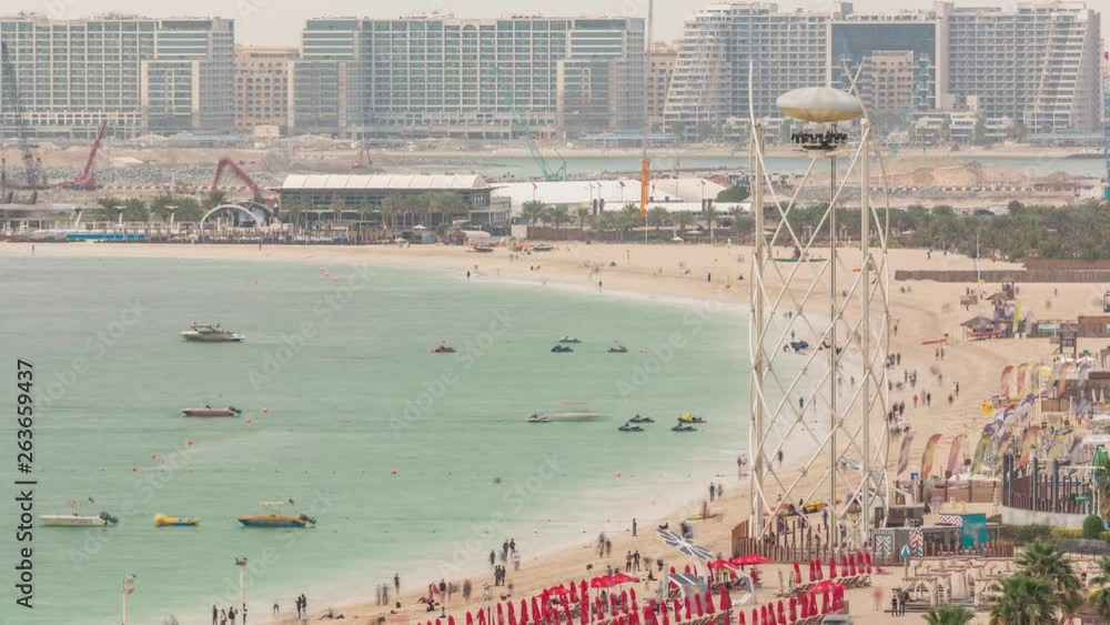 Aerial view of beach and tourists walking and sunbathing on holiday in JBR timelapse in Dubai, UAE. Waterfront with many activities and attractions, shops and restaurants Aerial view of beach and tourists walking and sunbathing on holiday in JBR timelapse in Dubai, UAE. Waterfront with many activities and attractions, shops and restaurants