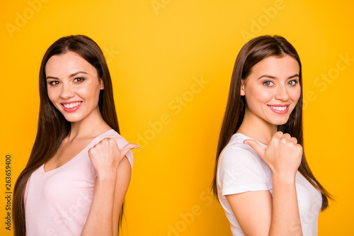 Close-up portrait of nice cute charming winsome lovely attractive cheerful cheery straight-haired ladies pointing thumbs back aside isolated over bright vivid shine background