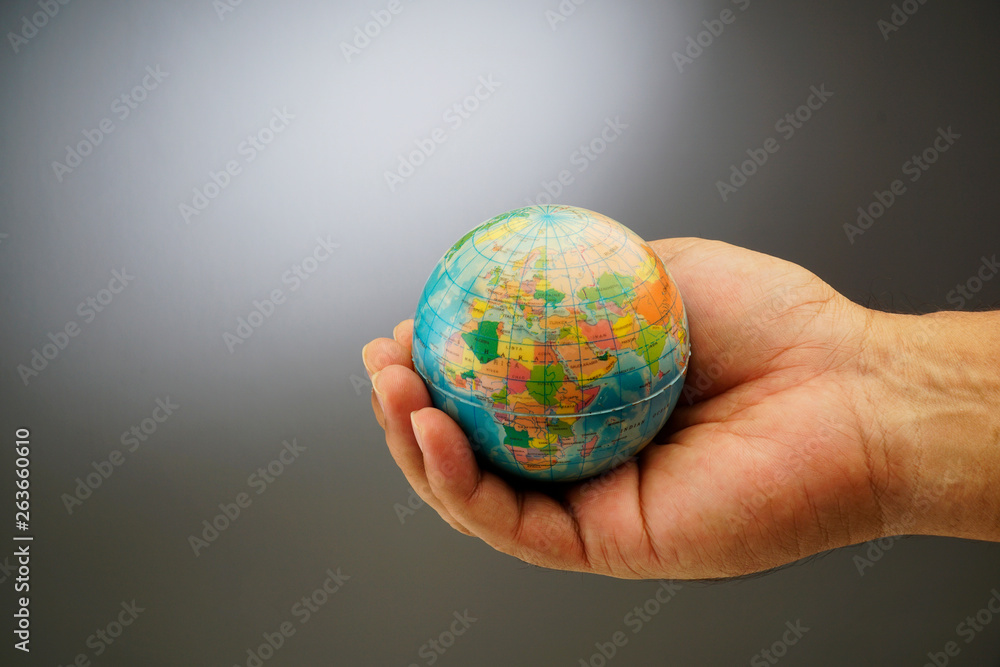 World globe on a palm over a grey background. Globalization Concept World globe on a palm over a grey background. Globalization Concept