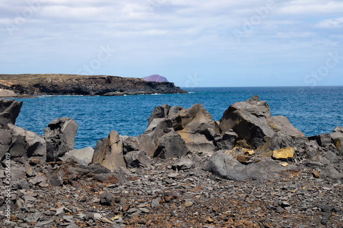 View at the ocean with the volcanic rocks and faraway island, Tenerife, Canary Islands, Spain - Image