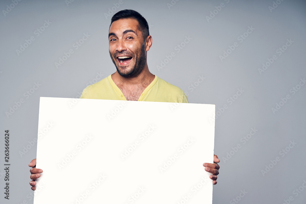 Happy laughing hispanic man holding blank white board Happy laughing hispanic man holding blank white board