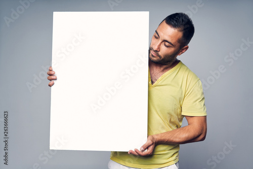 Man holding blank white board with copy space for text photo