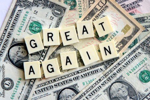 Make America Great Again signage on a bed of wealthy dollar notes.