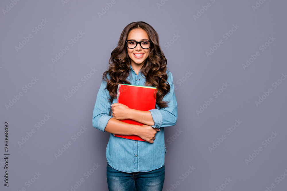 Portrait of her she nice lovely sweet winsome fascinating attractive cheerful cheery confident wavy-haired lady holding colorful red exercise-book exam isolated over gray pastel background Portrait of her she nice lovely sweet winsome fascinating attractive cheerful cheery confident wavy-haired lady holding colorful red exercise-book exam isolated over gray pastel background