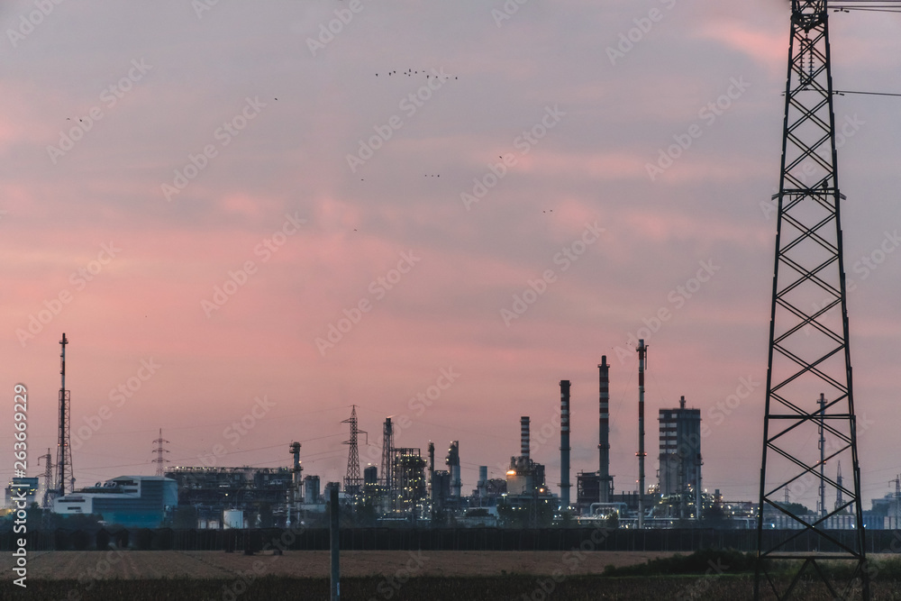 industrial factory on sky sunset background, Petrochemical plant with sky evening background. Northern Italy work in a modern enterprise
