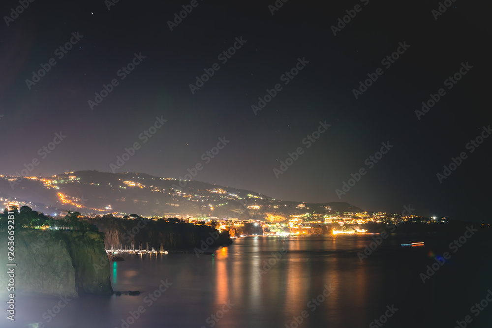Fototapeta premium Night scene of Sorrento, the pier with lots of yachts, a corner of the cityscape on a summer night, Amalfi coast, Italy