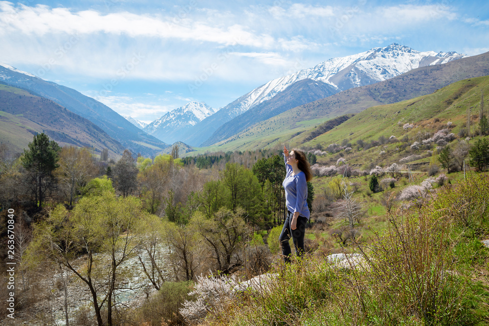 Plakat Young girl on the background of spring mountains. Beautiful mountain gorge. Nature and adventure.