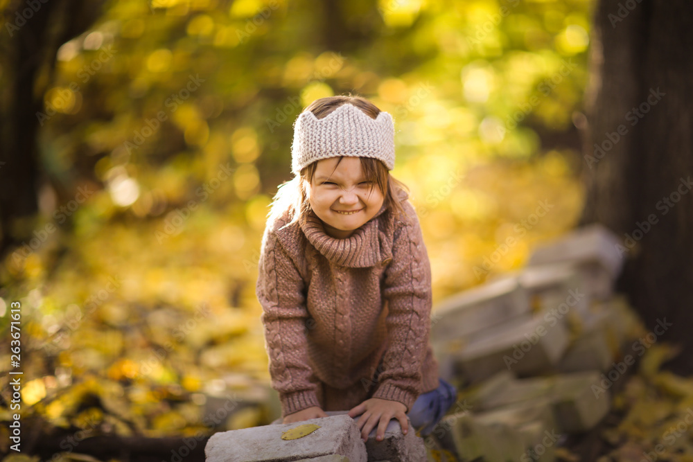 Fun girl playing in autumn park, knitted sweater Fun girl playing in autumn park, knitted sweater