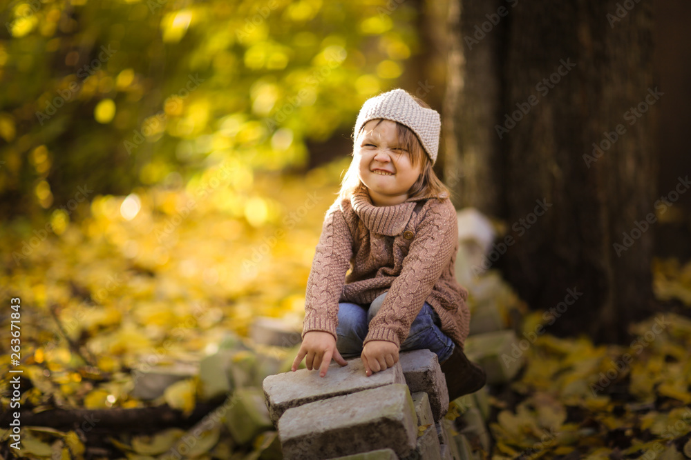 Fun girl playing in autumn park, knitted sweater Fun girl playing in autumn park, knitted sweater