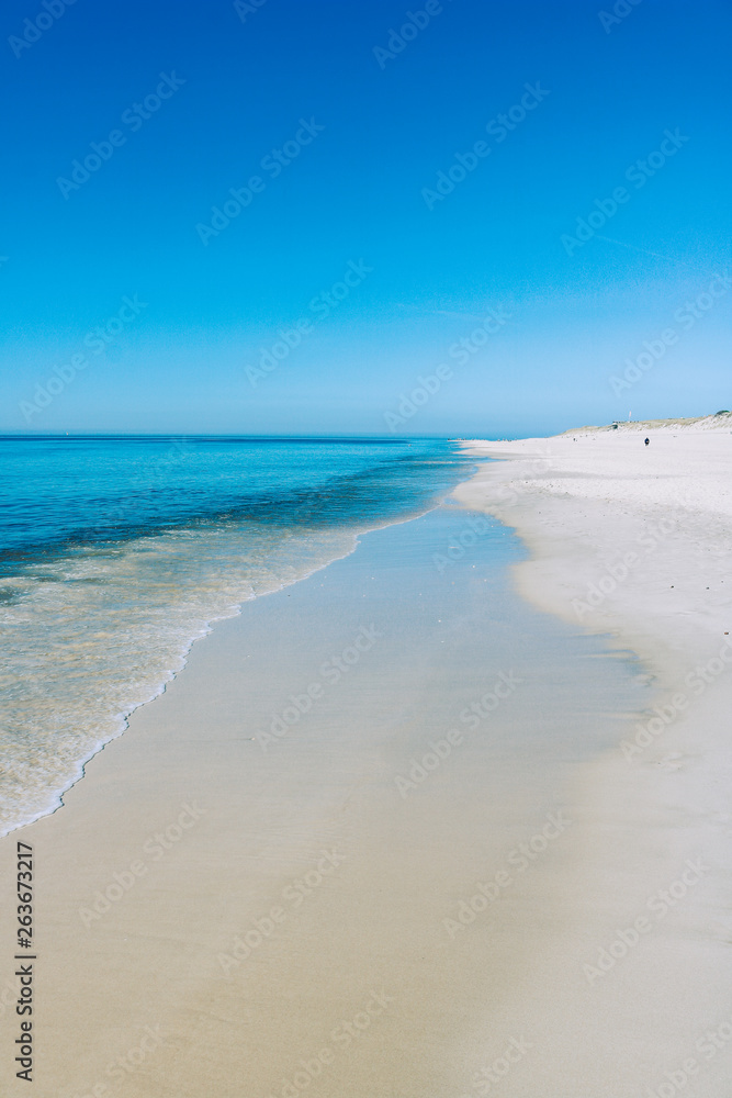 Beach with white sand calm water and clear blue sky, Sylt, Germany