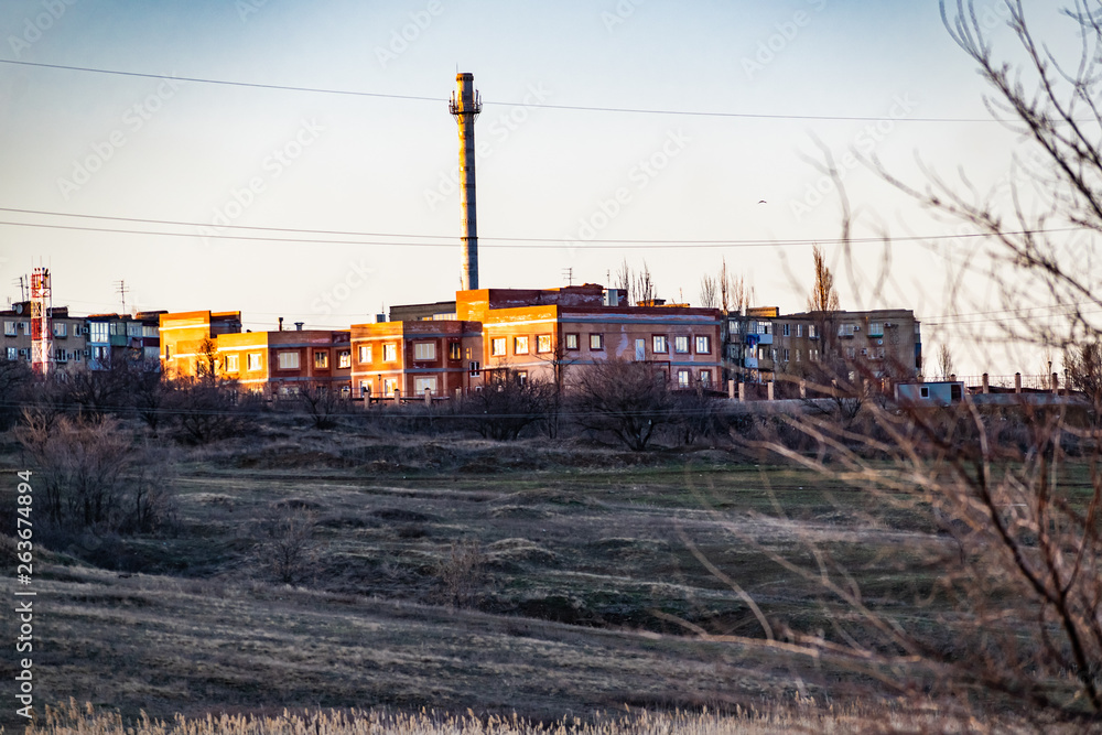 Multi-storey brick houses, construction of residential buildings in the distance, in the Rostov region in Russia. In beautiful light at sunset in cloudy weather.
